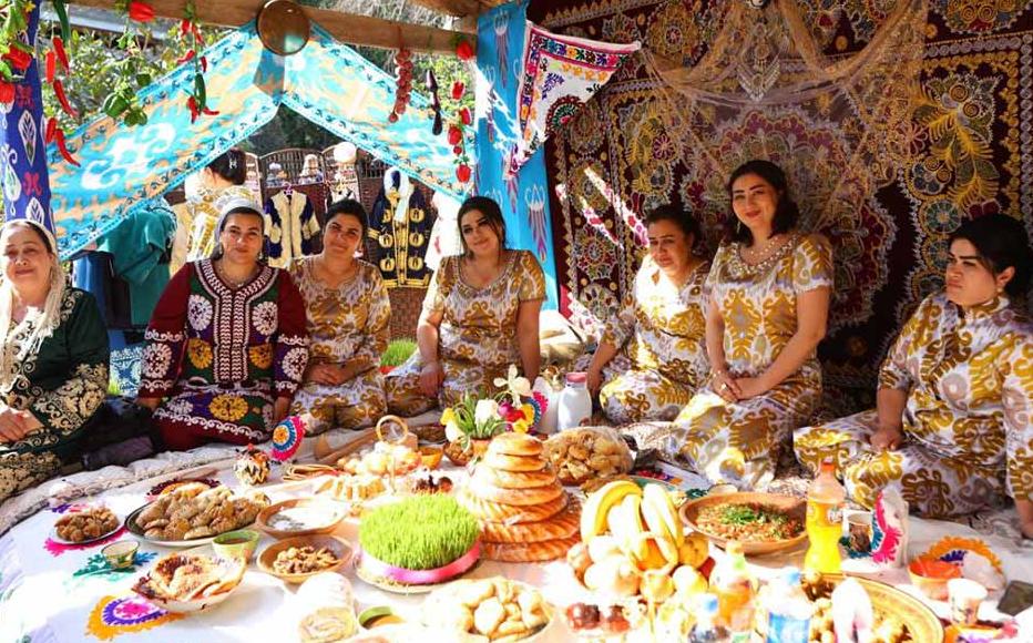 Tajik women sit at a covered dastarkhan, a traditional space where food is eaten. It comes from the Turkic word meaning tablecloth.