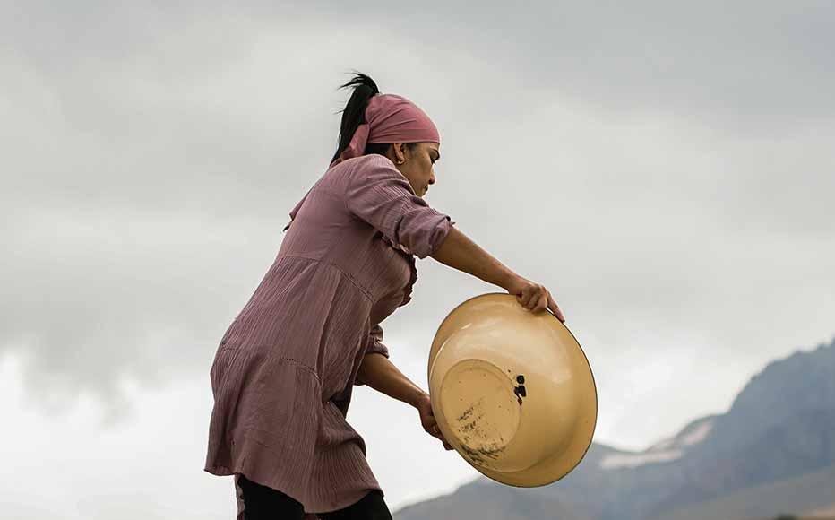 A woman pours grain on the roof. Some of the village’s oldest houses have an earthen roof and residents use the surface to dry fruit and grain. A woman pours grain on the roof. Some of the village’s oldest houses have an earthen roof and residents use the surface to dry fruit and grain.