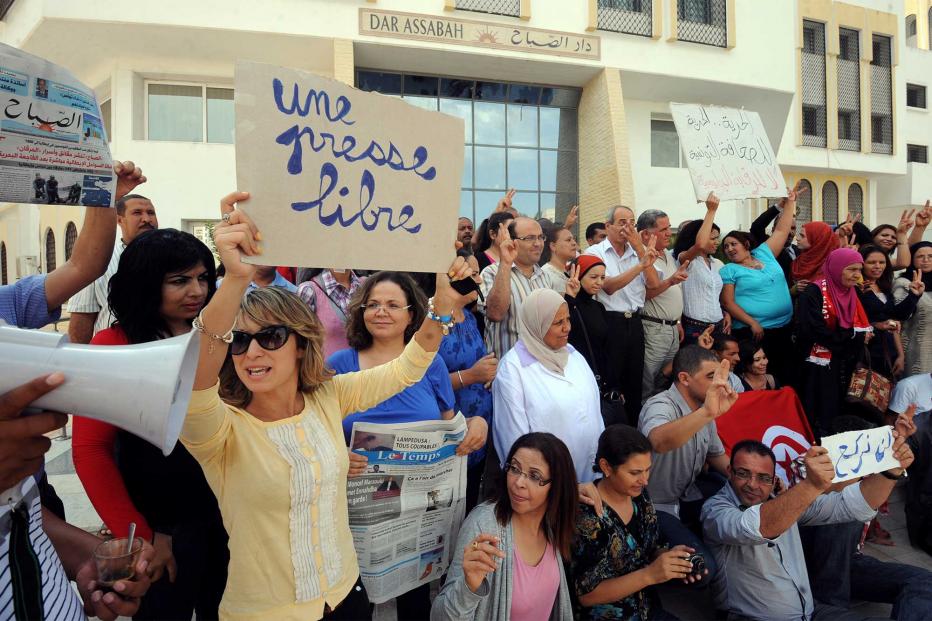 Tunisian journalists of Assabah daily hold signs calling for freedom of the press during a protest in Tunis on September 11, 2012.