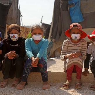 Displaced Syrian girls wear face masks decorated by artists during a COVID-19 awareness campaign at the Bardaqli camp in Syria's Idlib province, on April 20, 2020.