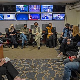 Reporters for Tolo News cover their faces as they attend an editorial meeting at Tolo TV station in Kabul on May 22, 2022.