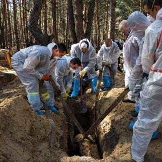 Rescue workers and forensic police exhume bodies from unidentified makeshift graves at the Pishanske cemetery on September 21, 2022 in Izium, Ukraine. The bodies will be examined by forensic officials for possible war crimes.