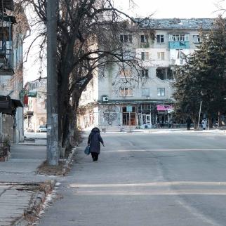 A woman walks through the heavily damaged town of Izyum on January 11, 2023 in Izyum, Ukraine. Izyum was occupied by the Russian military following the invasion of Ukraine and was heavily damaged in the subsequent fighting.