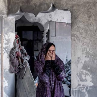 A woman reacts as she stands in a heavily damaged house following Israeli bombardment in Rafah in the southern of Gaza Strip on October 19, 2023. 