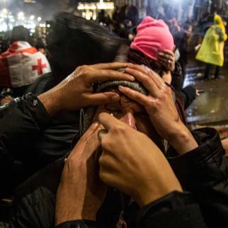 Demonstrators helping each other with effects from tear gas during a protest outside the parliament on November 29, 2024 in Tbilisi, Georgia.