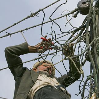 Electric power lines are vulnerable to sabotage and failure. (Photo: Paula Bronstein/Getty Images) An electrician works on power lines in Kabul. (Photo: Paula Bronstein/Getty Images)