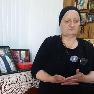 Giga Otkhozoria's mother, Julieta Chanturia, sits in her home with photos of her son. (Photo: Tamuna Shonia)