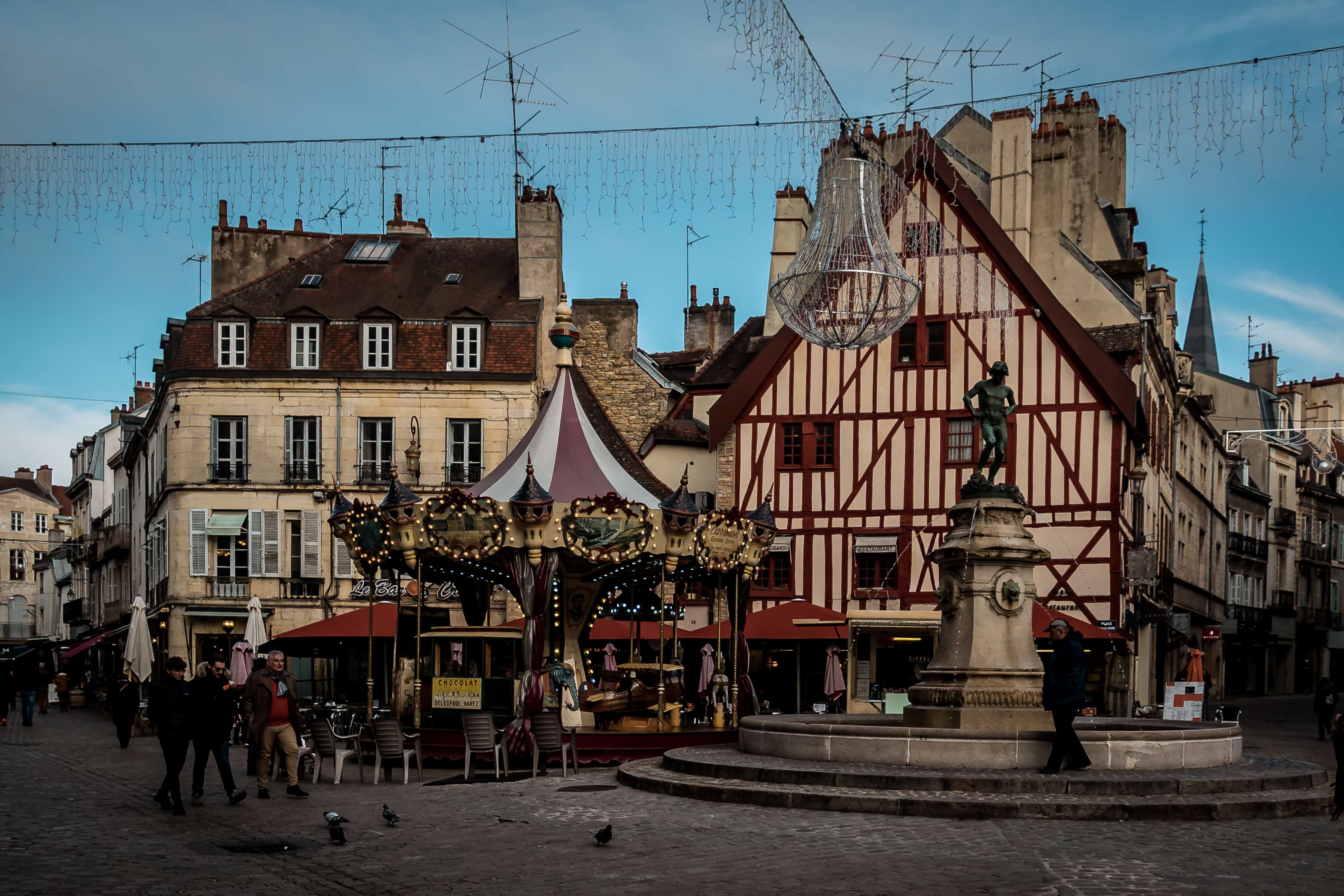 Platz mit Brunnen, Karussell und Fachwerkhäusern in Dijon