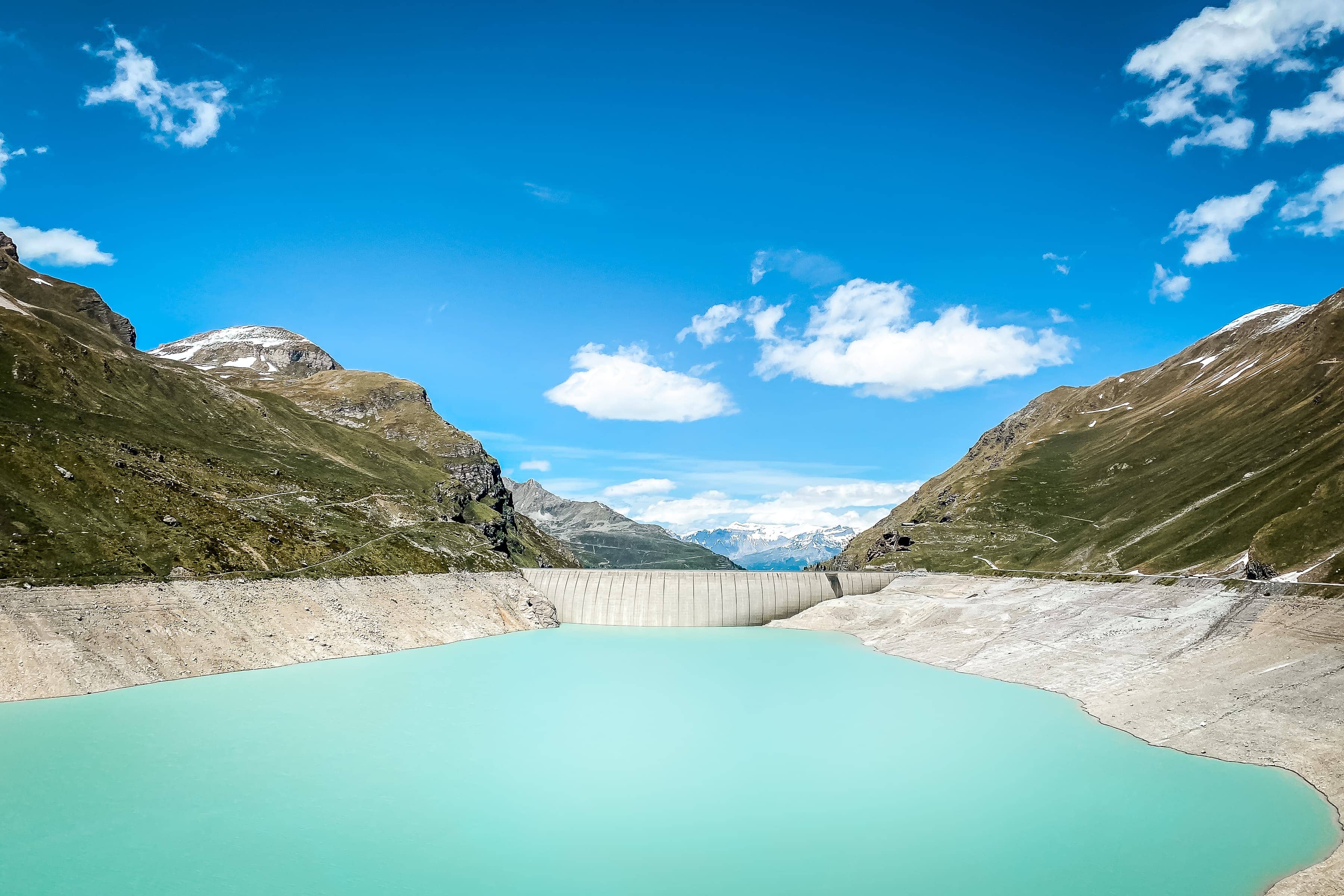 türkisfarbener Stausee und Staumauer