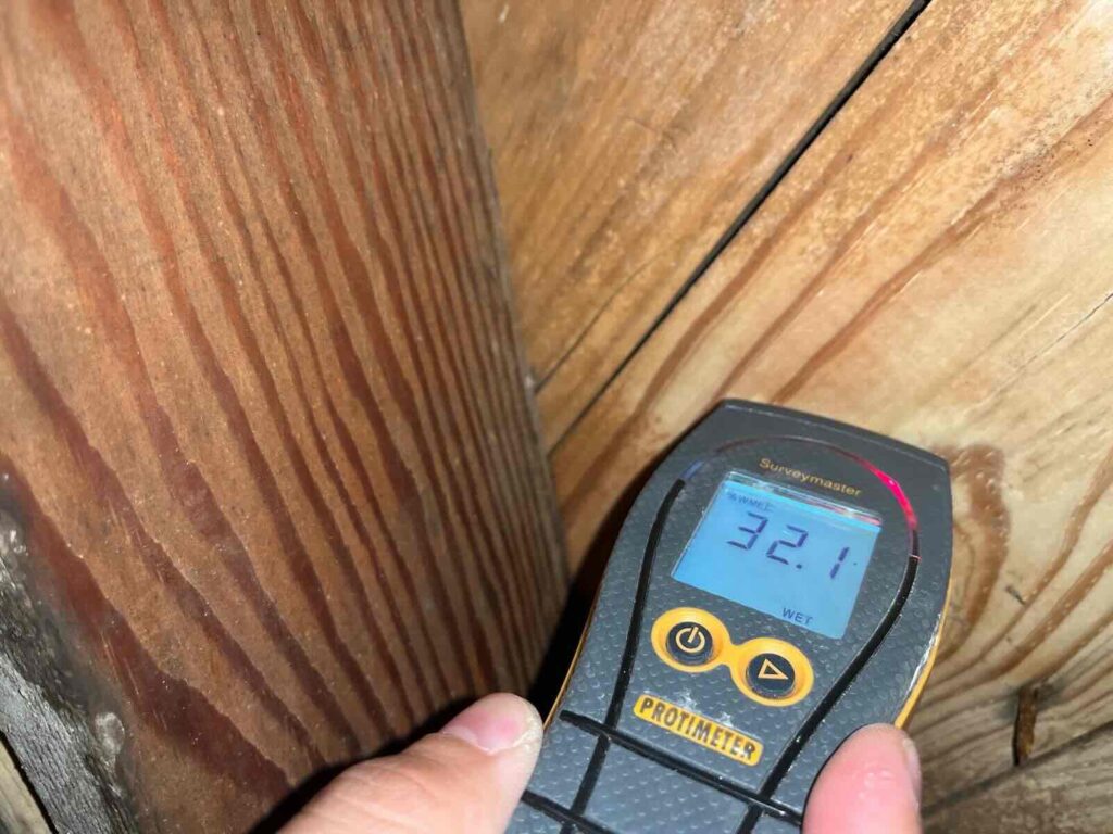 Technician taking a wood moisture reading in a North Texas crawl space