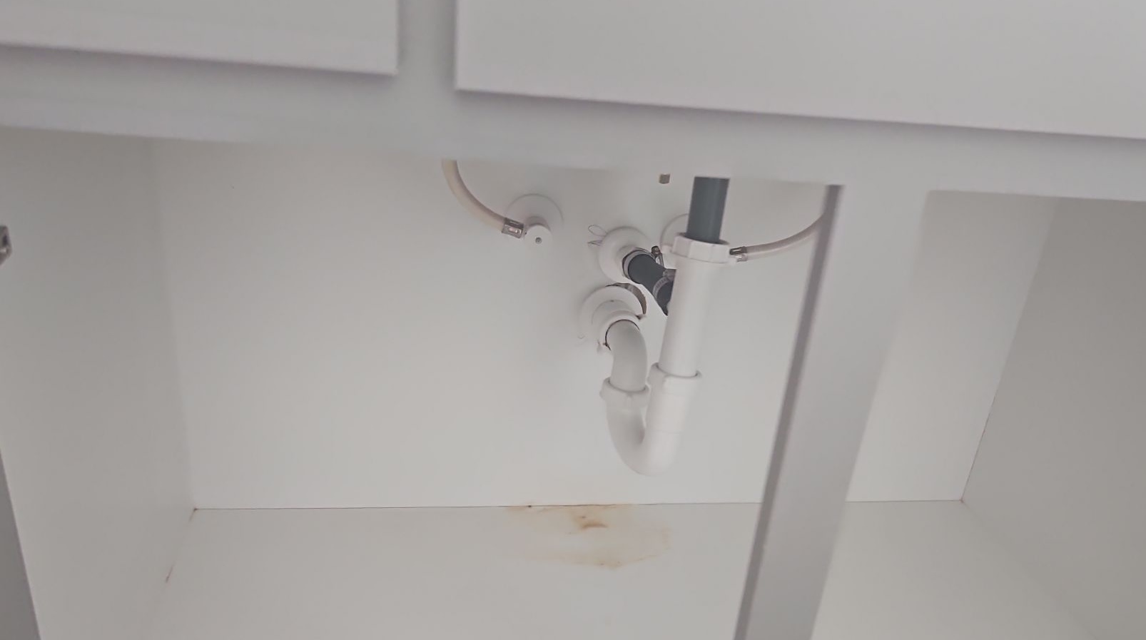 Cabinet Moisture staining inside a sink cabinet below the plumbing