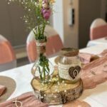 Blumen und Kerze auf rustikalem Holzstück bei Bürgerverein Lindweiler.