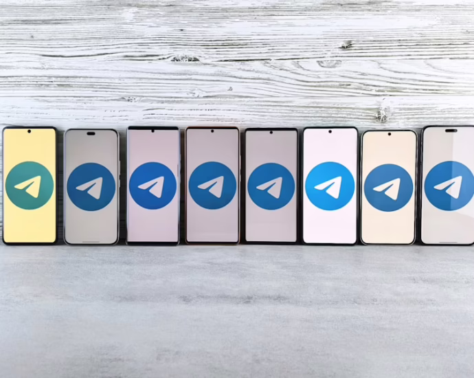 Reihe von Smartphones mit dem Telegram-Logo auf dem Bildschirm in verschiedenen Farben.