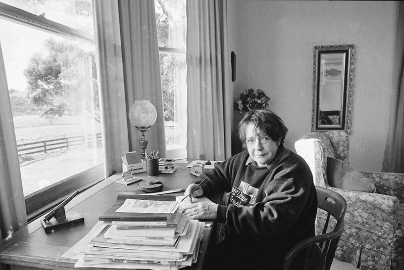 Image of Margaret Scott sitting at a desk with a pen and paper.