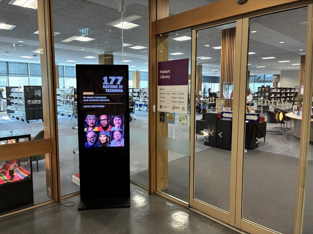 A library entrance with a digital screen in front.