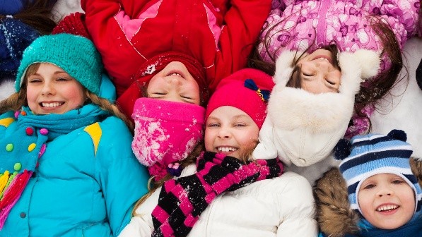 A group of children outside in winter gear having fun.