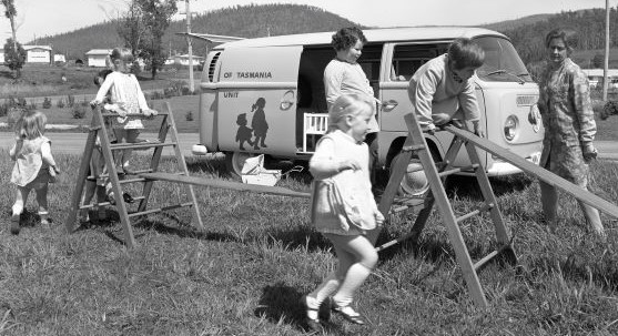 And old black and white photo of children playing on balance equipment.