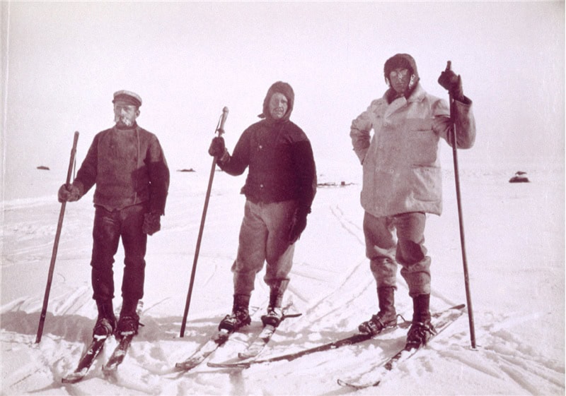 3 men on skies, standing in the snow.
