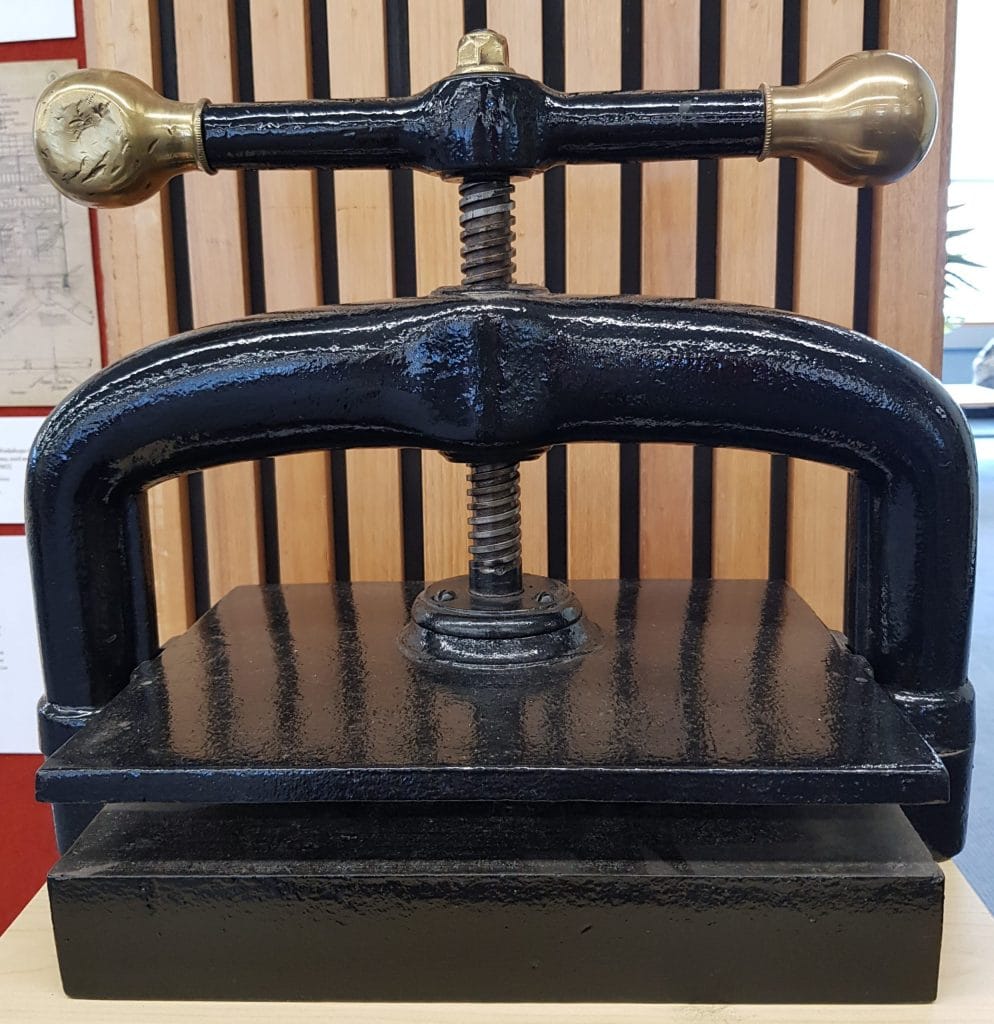 A copy press. Has a handle that screws a metal plat down.