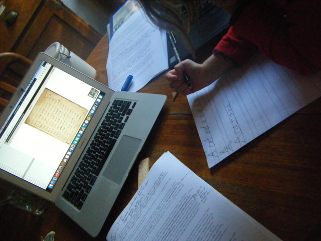 A photo of a young girl Learning her writing in front of a laptop.
