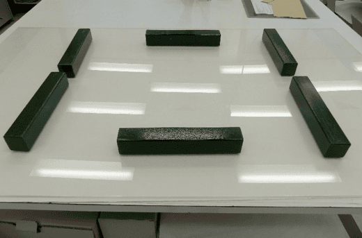 6 long blocks on top of a plastic sheet