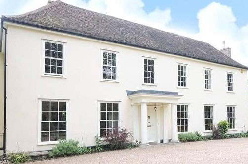 A photo of a 2 story, white hotel as seen from the front