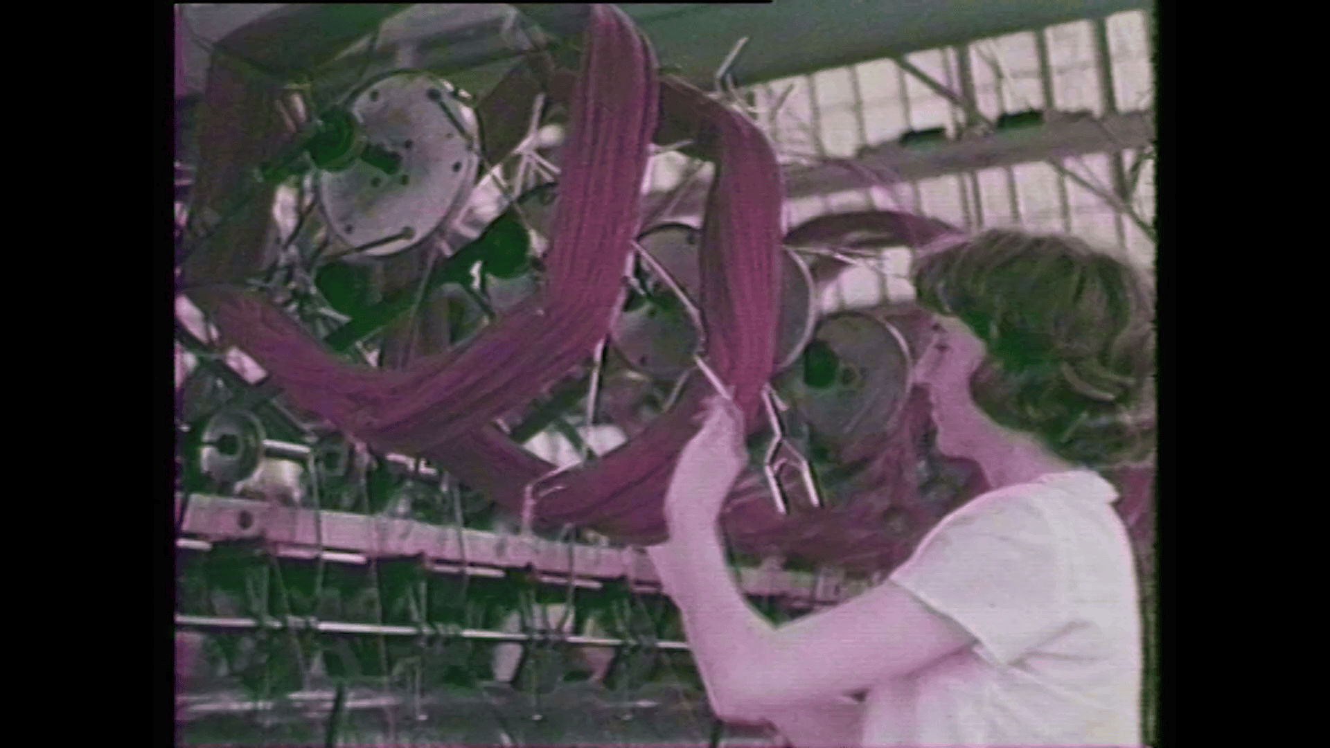 a still taken from Film – More Than Apples. A woman working with machinery.