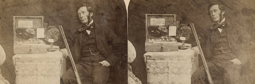 An old photo of a man sitting next to some relics.