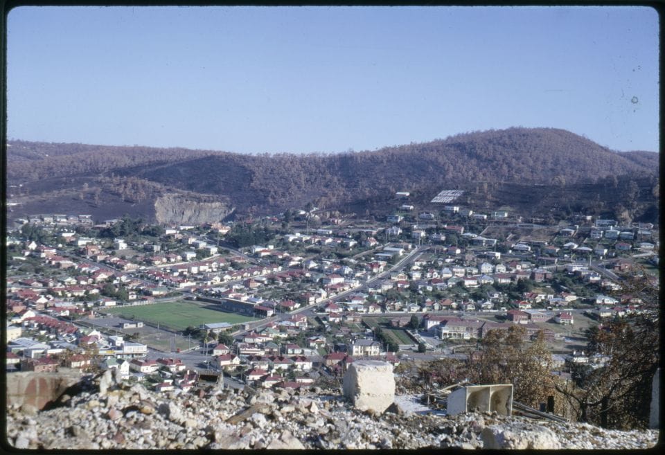 An ariel view of Hobart. Hills with burnt trees in the distance.