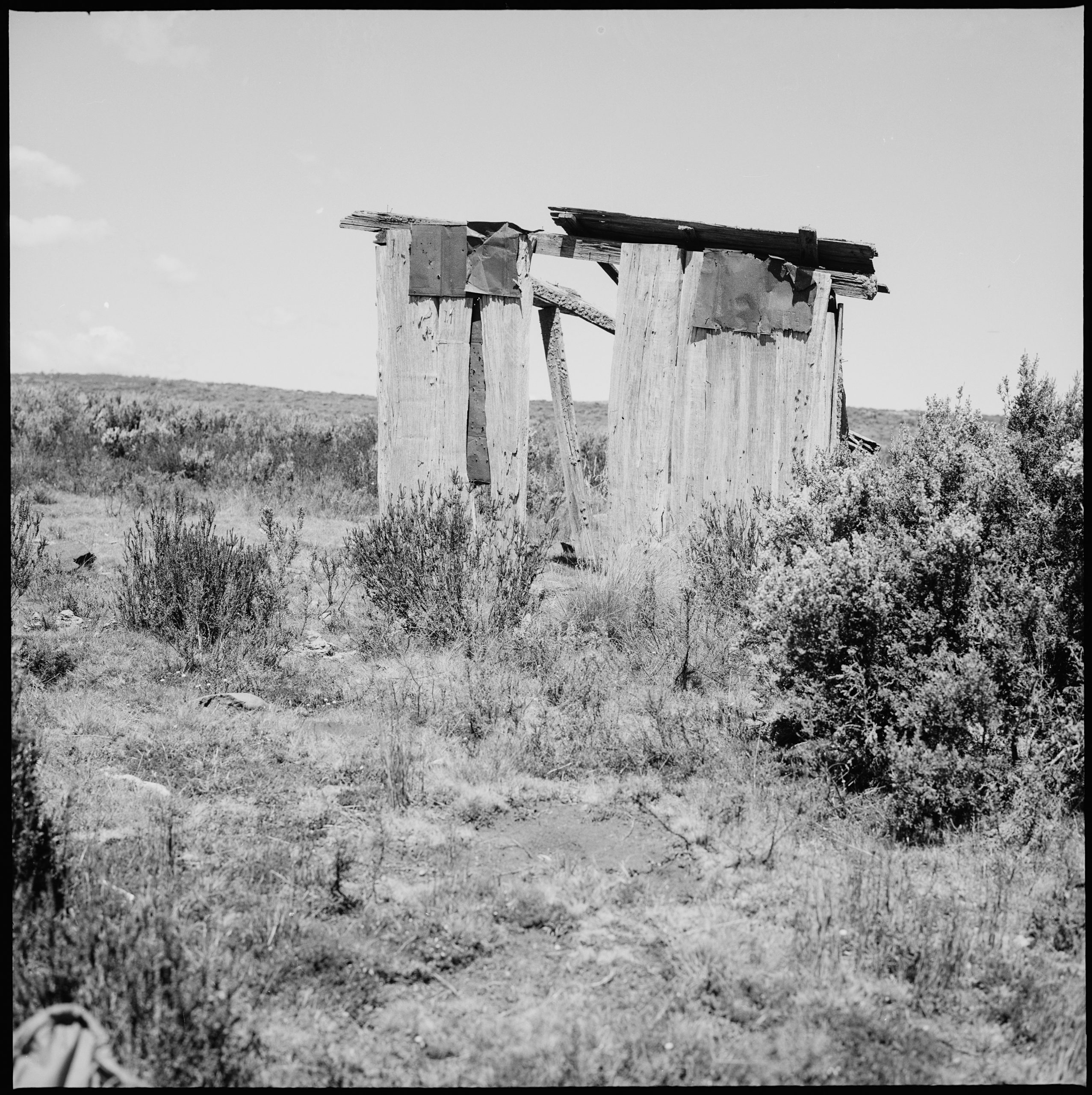 A black and white photo of an old pavilion at an old cricket pitch.