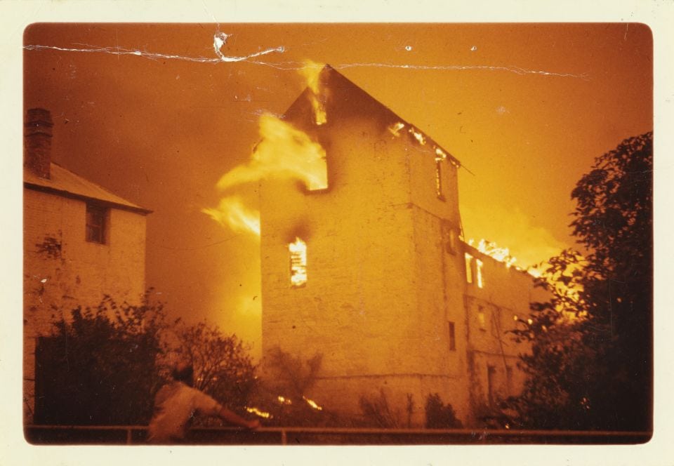 A photo of a 3 story building on fire.