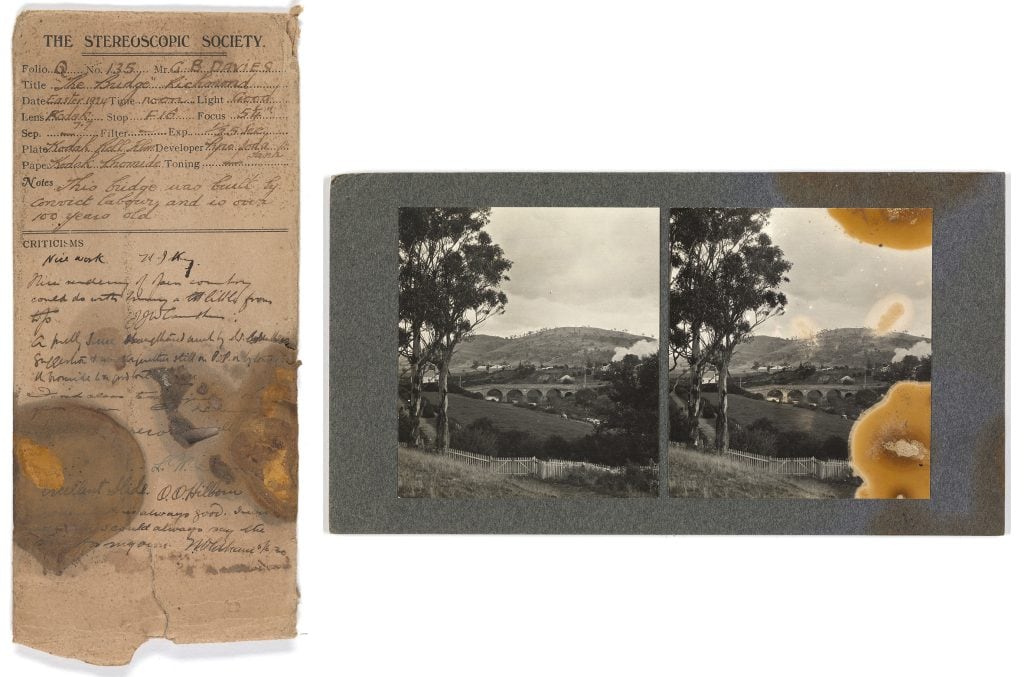 2 images. left image is a slip detailing information about how photos were taken. The title reads: "The stereoscopic society".. The right image is of 2 photo's of a bridge with hills and buildings in th distance. Both photos are the same, but one is stained.