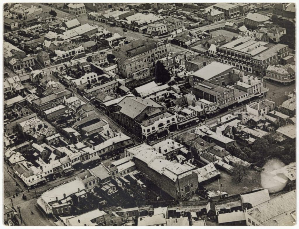 An old black and white photo of an ariel view of some buildings and streets