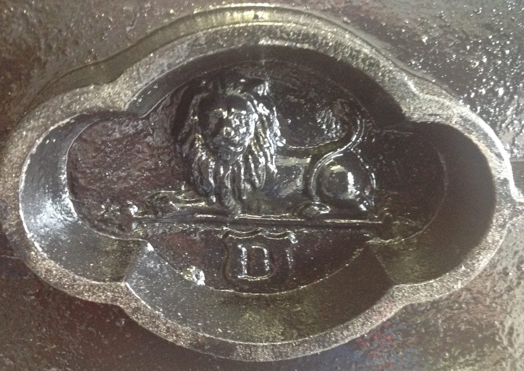 A photo of a markers mark on a copy press. the mark is of a lion and a letter D underneath.