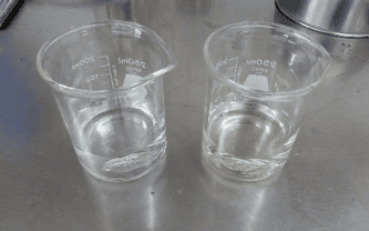 2 beakers. the left beaker has clean water. the right has dirty water.
