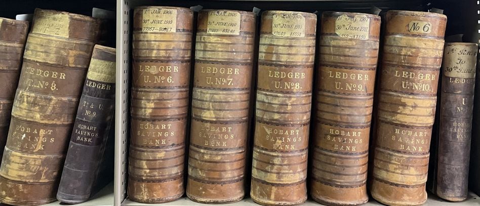 A row of old Ledger books on a shelf