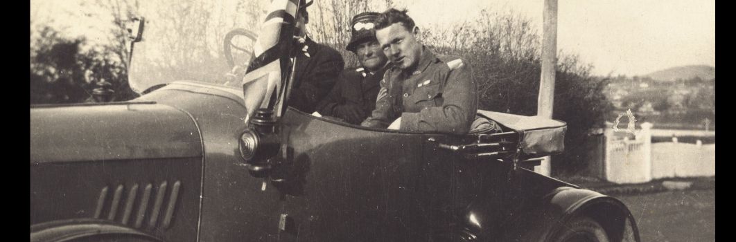A picture of 3 people sitting in an old car