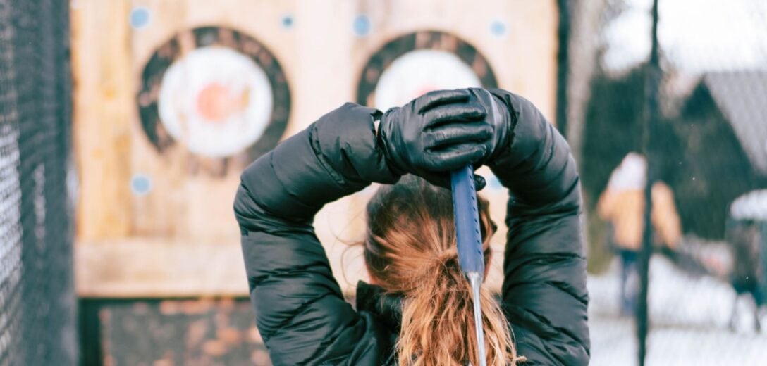 woman getting ready to throw an axe at a target