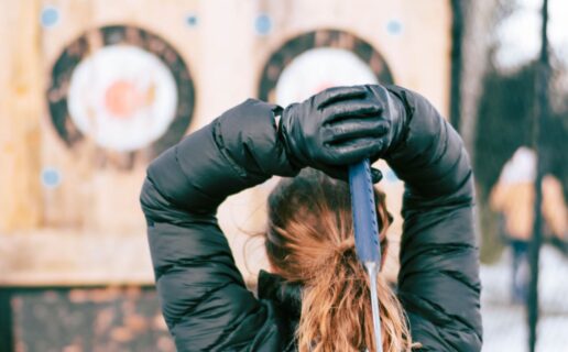 woman getting ready to throw an axe at a target