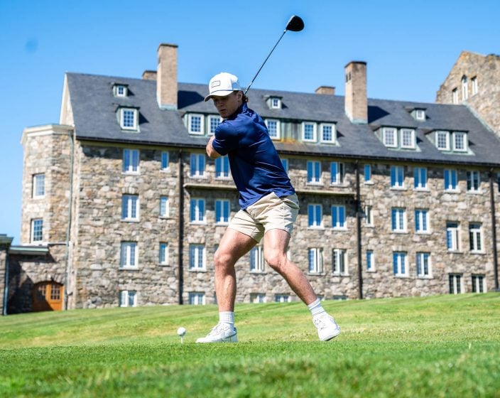a young boy playing golf