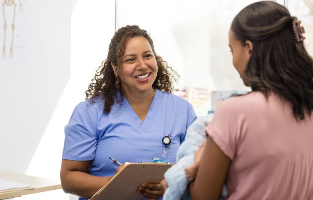 Woman in scrubs taking notes