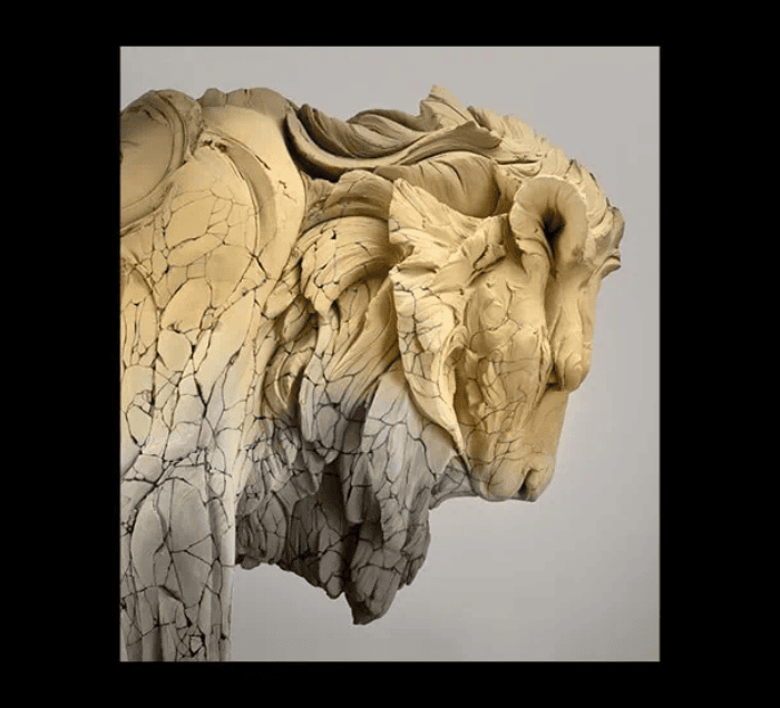 A sculpture of a horse’s head with a cracked, weathered texture and flowing, stylized features, set against a plain gray background with a black border—an artwork evocative of the Royal Society for the Arts' dedication to creativity.
