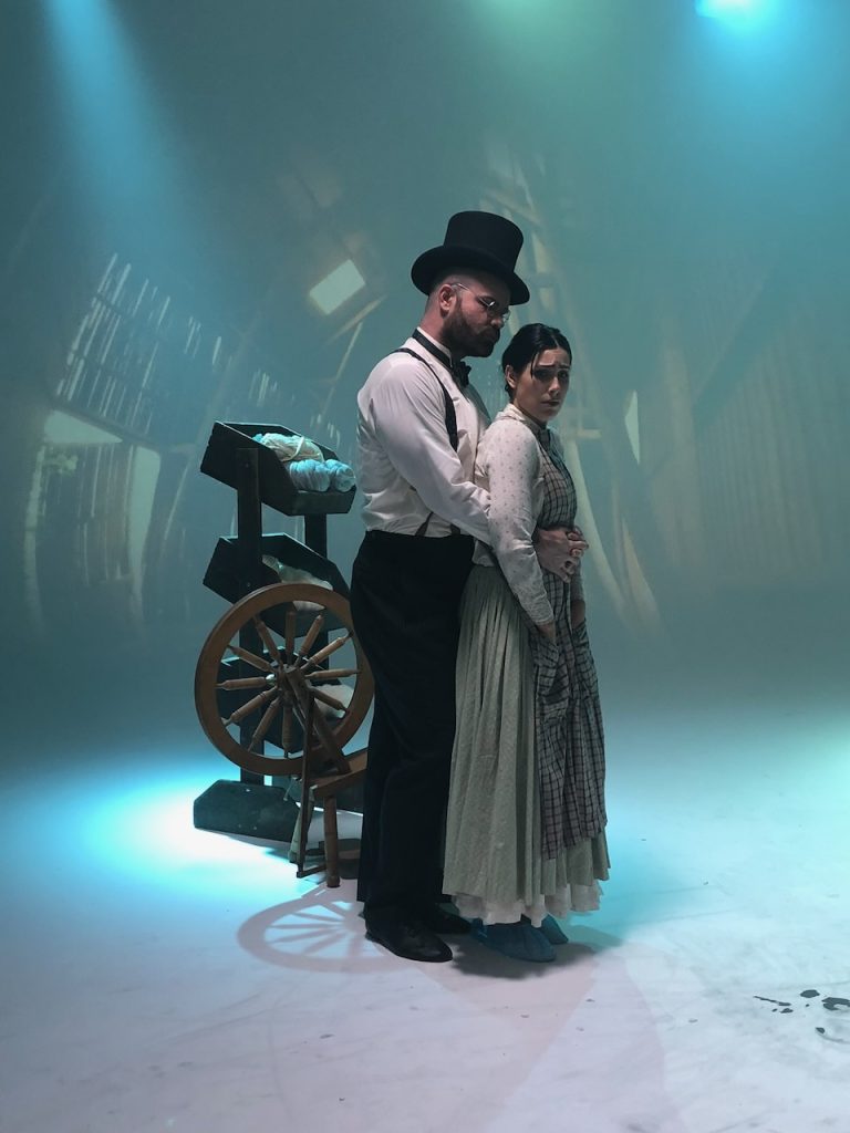 Two actors in period costume on atmospheric film set with ship's wheel, Tulsa Opera Ad Campaign 2019