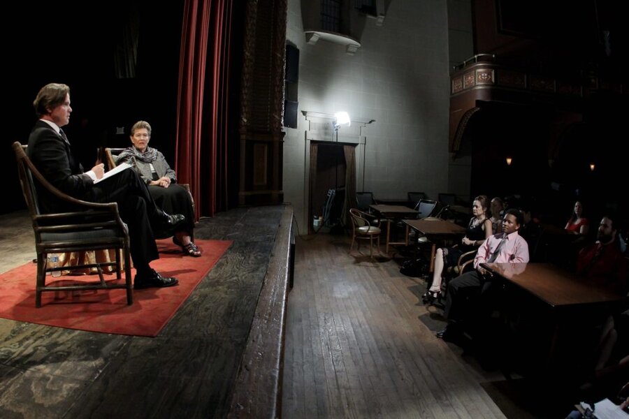 Final Acts interview scene with interviewer and subject seated on stage, audience watching from floor level
