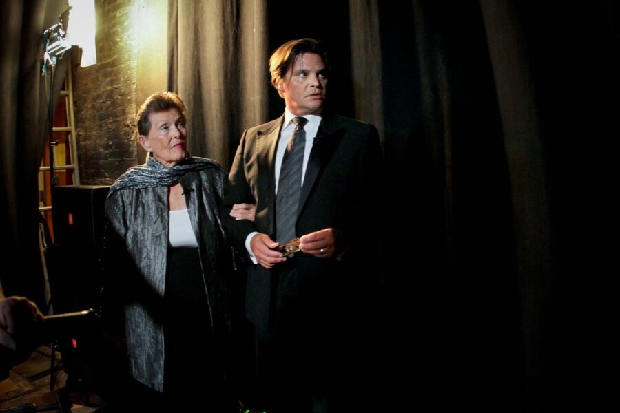 Two actors in formal attire standing together in dimly lit interior during Final Acts film production