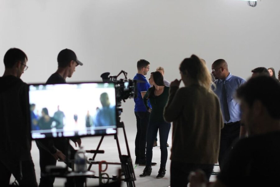 Director and crew prepare talent on a backlit commercial set with monitors and camera gear in Los Angeles studio