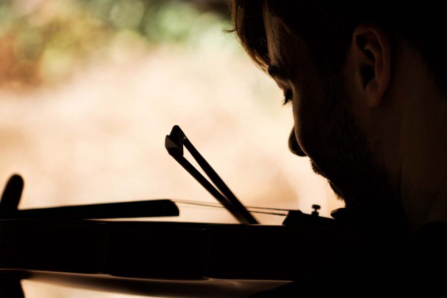 Silhouetted musician eating noodles with chopsticks outdoors, warm backlit glow, Branches music video production
