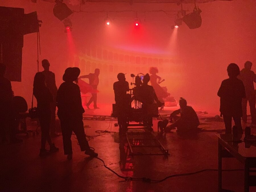 Film crew prepares atmospheric red-lit stage scene for Tulsa Opera commercial shoot directed by James Kicklighter