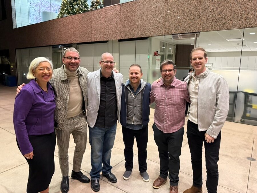Six people pose together in a theater lobby at The American Question screening in Beverly Hills with James Kicklighter