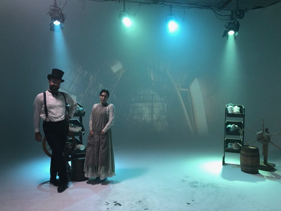 Two actors in period costume on atmospheric stage set with blue-green lighting, Tulsa Opera campaign